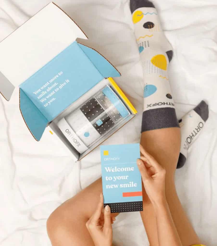 Opening clear aligners box and girl wearing socks withholding card | OrthoFx